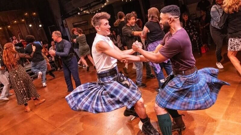 Ceilidh production photograph with dancers in kilts